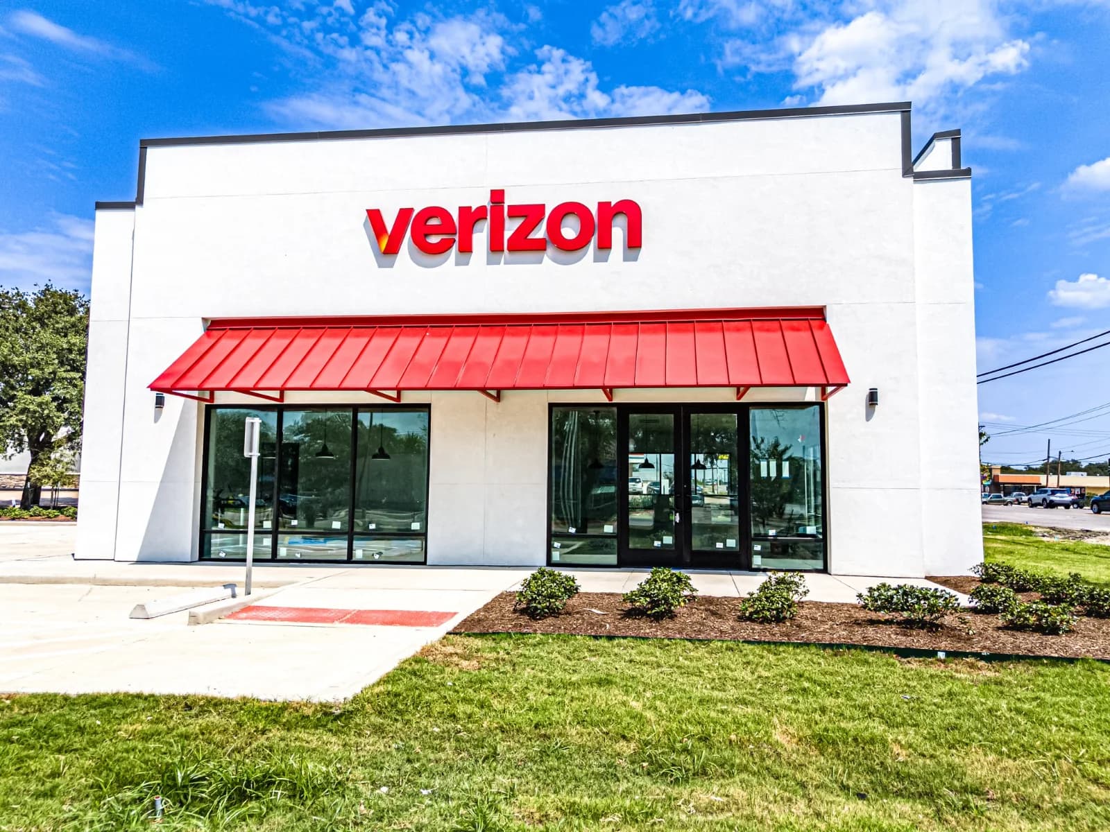 Completed Verizon retail store in Bryan, Texas with red canopy and glass storefront